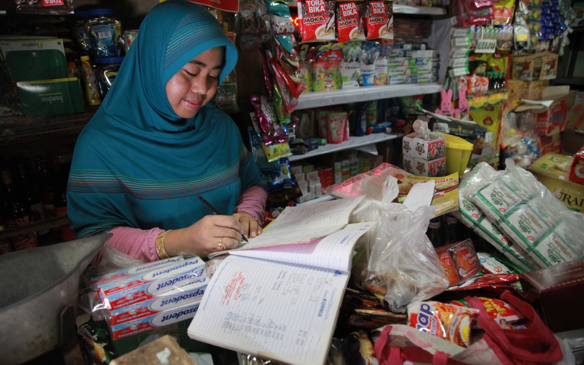A woman works on bookkeeping in her store. 
